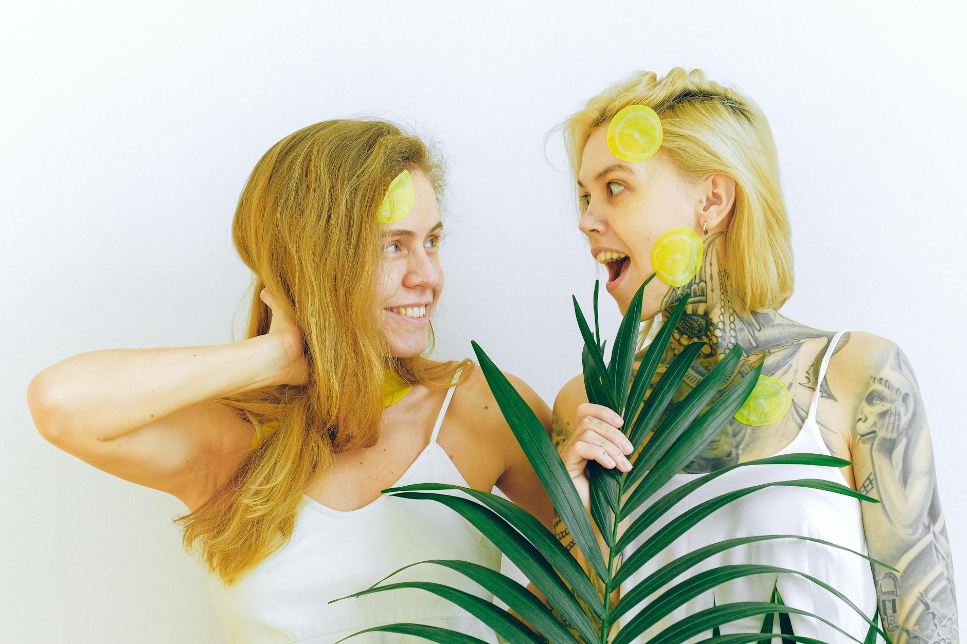 Due donne felici con fette di limone che esprimono gioia e divertimento insieme.