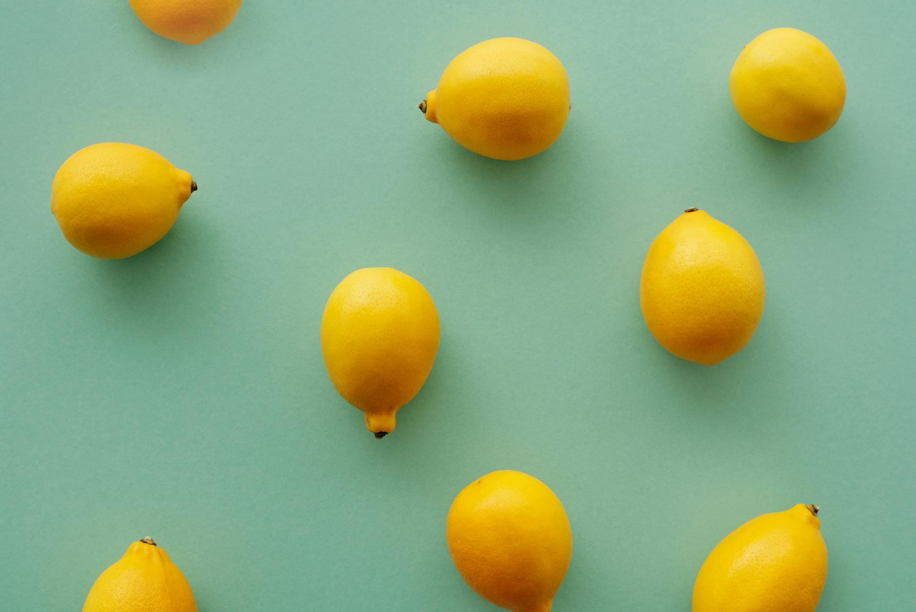 Limoni gialli freschi su sfondo verde pastello che rappresentano il tocco rinfrescante della stimolazione intermittente