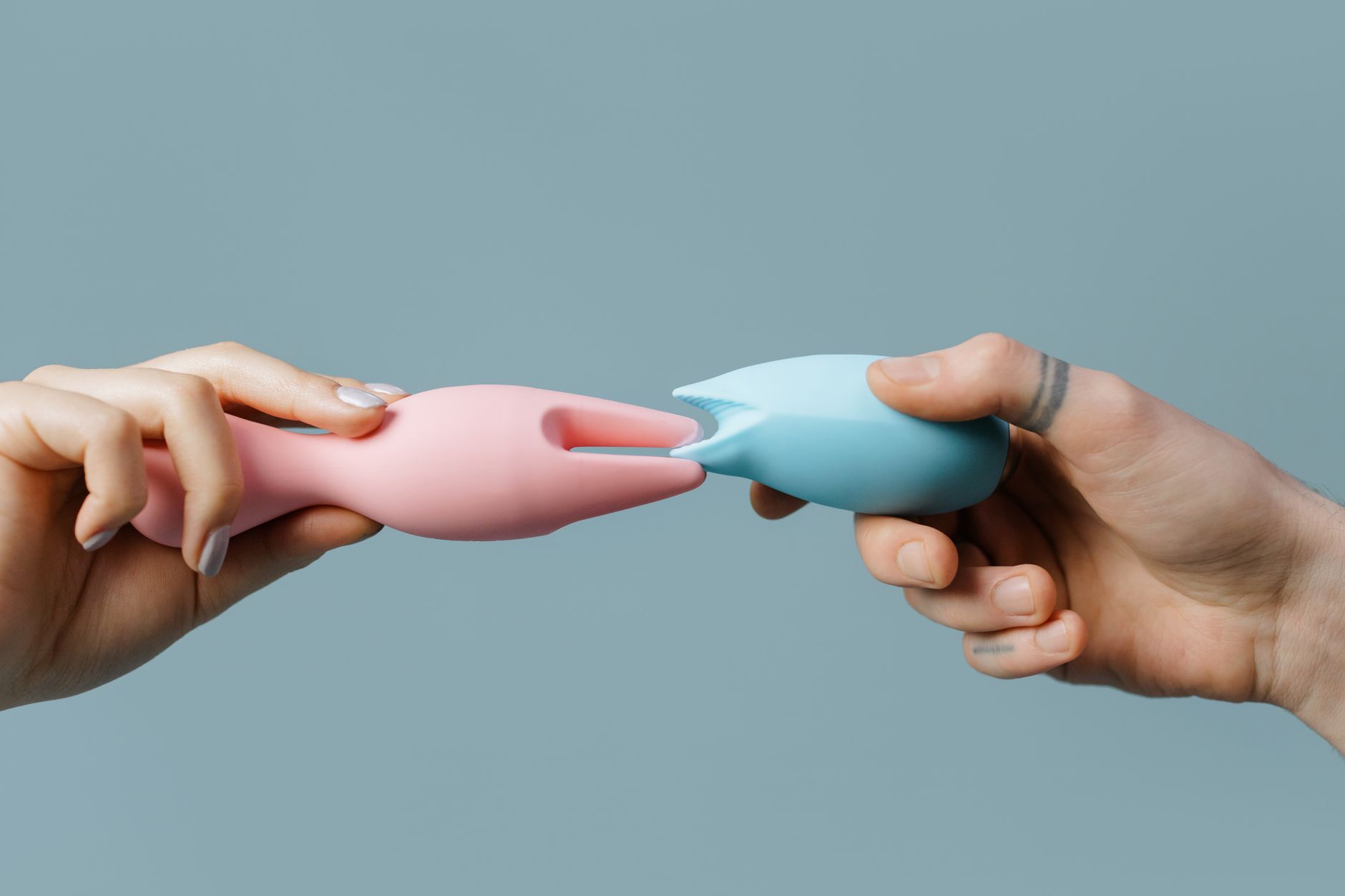 Hands holding pastel-colored silicone toys, perfect for adult and lifestyle themes