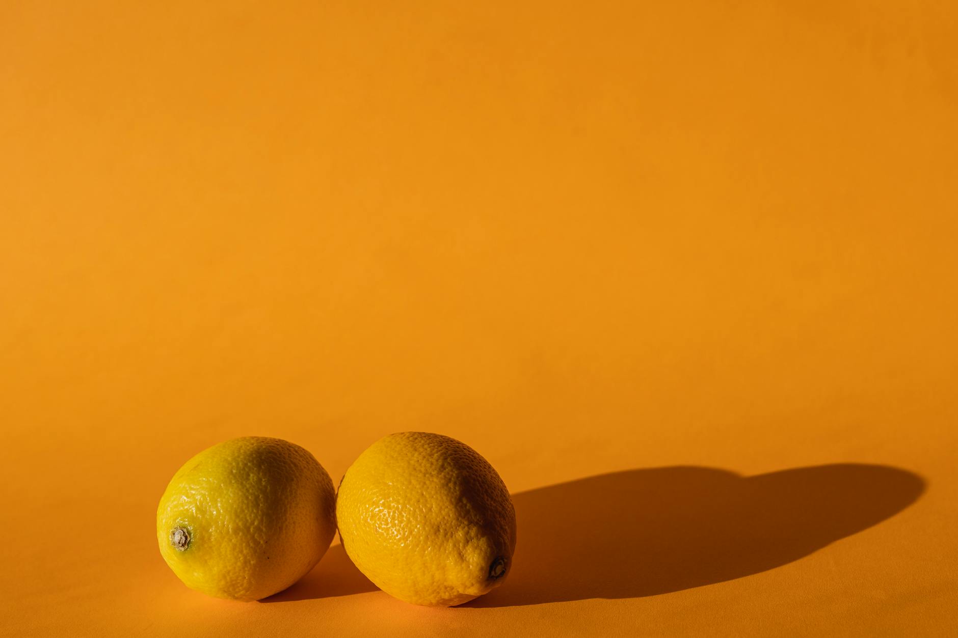 Limoni gialli vibranti composti su uno sfondo giallo in uno studio fotografico moderno